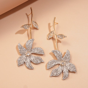 Detailed view of luxury floral drop earrings with sparkling rhinestones in gold finish