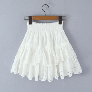 Détail d'une mini-jupe blanche en coton avec broderie ajourée et volants superposés