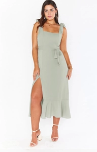 Detail of sage green midi dress with tie shoulder straps and ruffled slit hemline