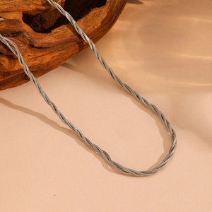 Detailed view of silver multi-strand twisted snake chain on a natural wood block background