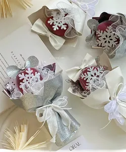 Close-up of snowflake pattern red ornament with glitter paper and ribbon bow gift wrap