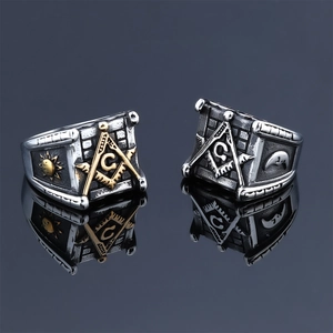 Vintage stainless steel Freemason rings with sun and moon emblems on a mirror background