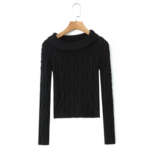 Detail of black cable knit sweater featuring classic braided texture and folded collar