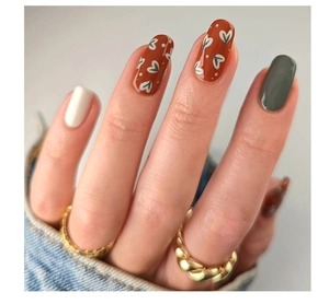 Macro detail of oval press-on nails with heart art design and solid color finish