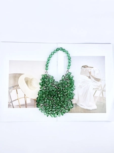 Detailed shot of green acrylic beaded handbag on a magazine showing the intricate handcraft