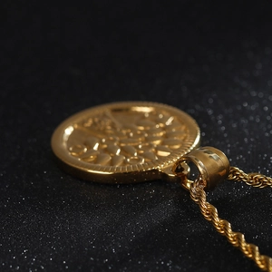 Macro view of golden stainless steel tree of life pendant with detailed twist chain