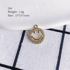 Macro view of gold plated smiley face charm pendant with white zircon stones 13x15mm