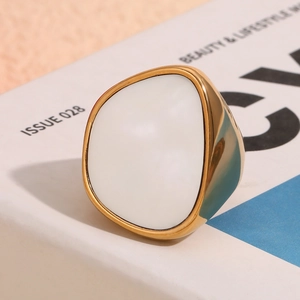 Makroaufnahme von 18K vergoldetem unregelmäßigem Ring mit weißem Emaille-Inlay auf Magazin