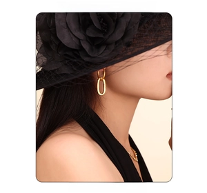 Chic gold double-loop chain earrings worn by a model with a mesh brim hat for style