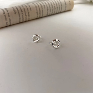 Macro detail of silver S925 sterling silver hoop earrings on vintage book page