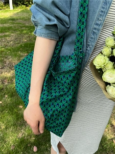Detail of green geometric pattern canvas tote bag with wide shoulder strap on model