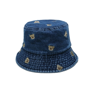 Close-up of deep blue denim fisherman hat with cute brown bear embroidery details