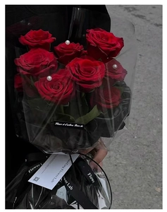 Close-up of red velvet roses with pearls and black designer flower lab gift wrap