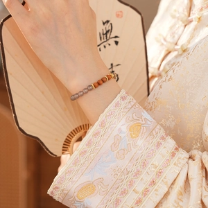 Détail d'un bracelet rétro en bois de santal et agate sur fond de style chinois classique