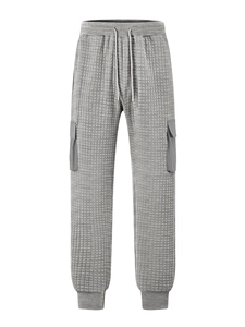 Detailed view of grey quilted cargo pants featuring textured square patterns and side pockets