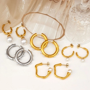 Elegant 18K gold hoop earrings with pearls and crystals on champagne silk fabric