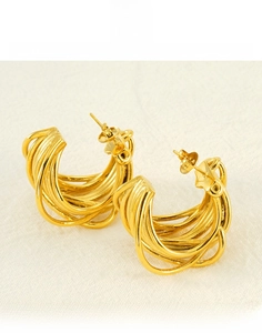 Detail view of multi-layered gold titanium steel C-shape earrings with a polished finish