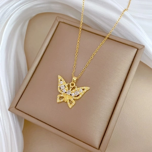 Detailed close-up of a hollow butterfly pendant with sparkling crystals on gold chain