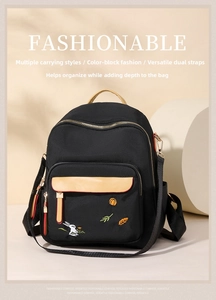 Close-up of elegant black backpack with rabbit embroidery and contrast leather details