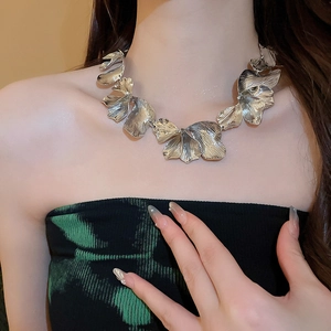 Close-up of luxury silver flower petal pendant necklace with organic textured metal fringe