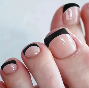 Macro close-up of nude toe nails with black French tips for a stylish manicure
