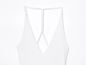 Detail of white ribbed knit fabric texture on a deep V-neck halter mini dress