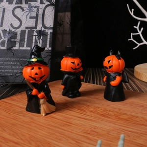 Three Halloween resin figurines featuring pumpkin witch, vampire and devil on a desk