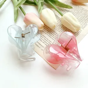 Close-up of translucent heart-shaped hair claws in blue and pink with marble texture