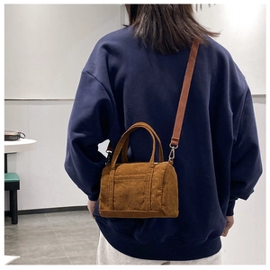 Brown corduroy Boston mini bag worn crossbody showing texture and scale on model