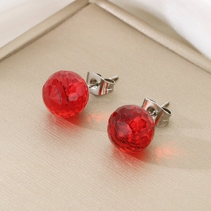 Detail of red faceted crystal stud earrings with metal butterfly back on display