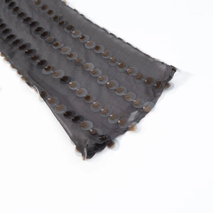 Macro view of translucent dark grey fabric with layered sequins and intricate stitching