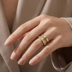 Detail view of gold Roman numeral ring, cable wire band, and pave diamond stacking set