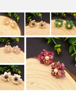 Detailed views of multi-color resin flower earrings with pearls on wood background
