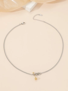 Detail view of two-tone K18 titanium dumbbell pendant necklace with silver and gold finish