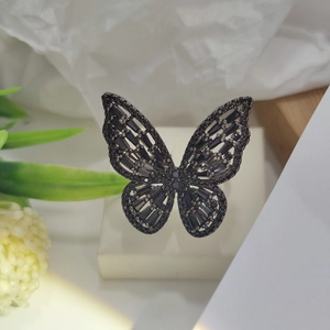 Detailed close-up of a butterfly-shaped open ring with black zircon stones