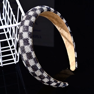 Detailed close-up of wide headband featuring black and white rhinestone geometric patterns