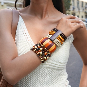 Bohemian style layered wooden beaded bracelet with geometric round floral charms on model