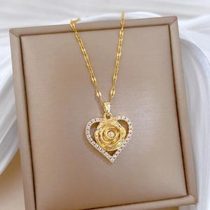 Gold heart necklace with zircon rose pendant displayed on an elegant jewelry box