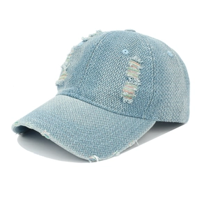 Detail of light blue denim baseball cap featuring distressed holes and rainbow stitching