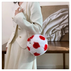 Detail of plush spherical bag with red spots and gold chain on a tweed outfit
