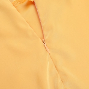 Gros plan sur la fermeture éclair invisible d'une robe de soirée en satin jaune vif