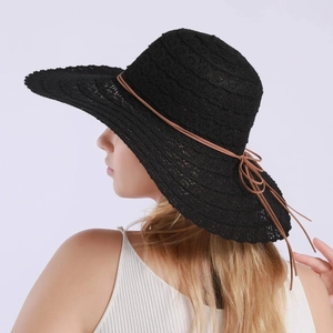 Detail of black lace crochet sun hat with brown rope bow and breathable wide brim