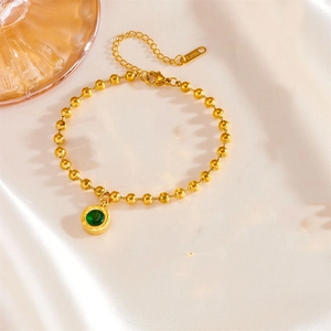 Detail of green gemstone pendant with Roman numeral engraving on golden bead chain