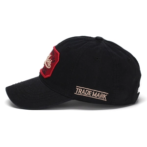 Close-up of vintage red embroidery and stitched details on black cotton New York baseball cap