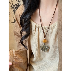 Bohemian long necklace featuring a bronze ginkgo leaf pendant and round wooden beads