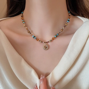 Detailed shot of bohemian beaded necklace with natural stones and golden sun pendant