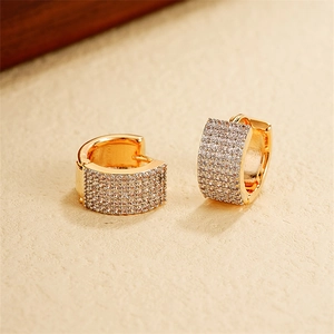 Macro shot of gold U-shaped huggie earrings featuring micro-pave clear cubic zirconia stones