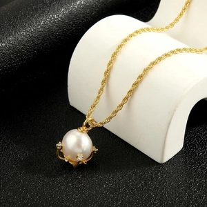 Detail of a pearl pendant in crown setting with small diamonds on golden twist chain