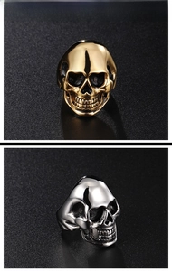 Close-up of gothic skull rings in polished gold and silver finish with dark accents