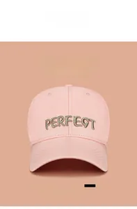 Détail d'une casquette rose clair avec broderie PERFECT dorée 3D et texture coton